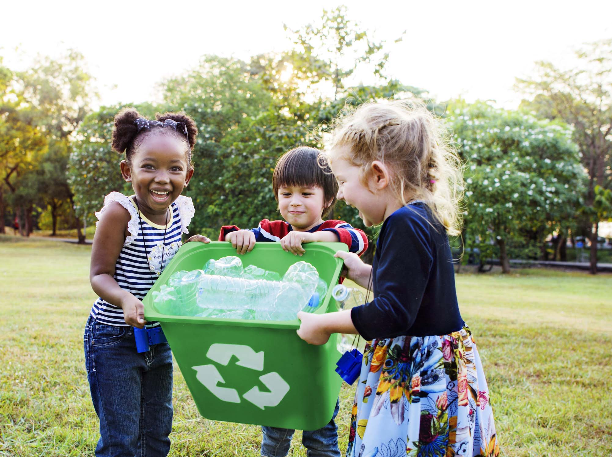 children carrying recycling bin